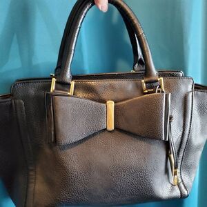 Black Leather Carlos Santana Bow purse with Red lining